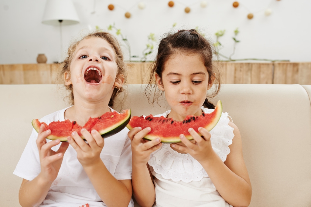 Imagem de duas meninas saudáveis comendo melancia